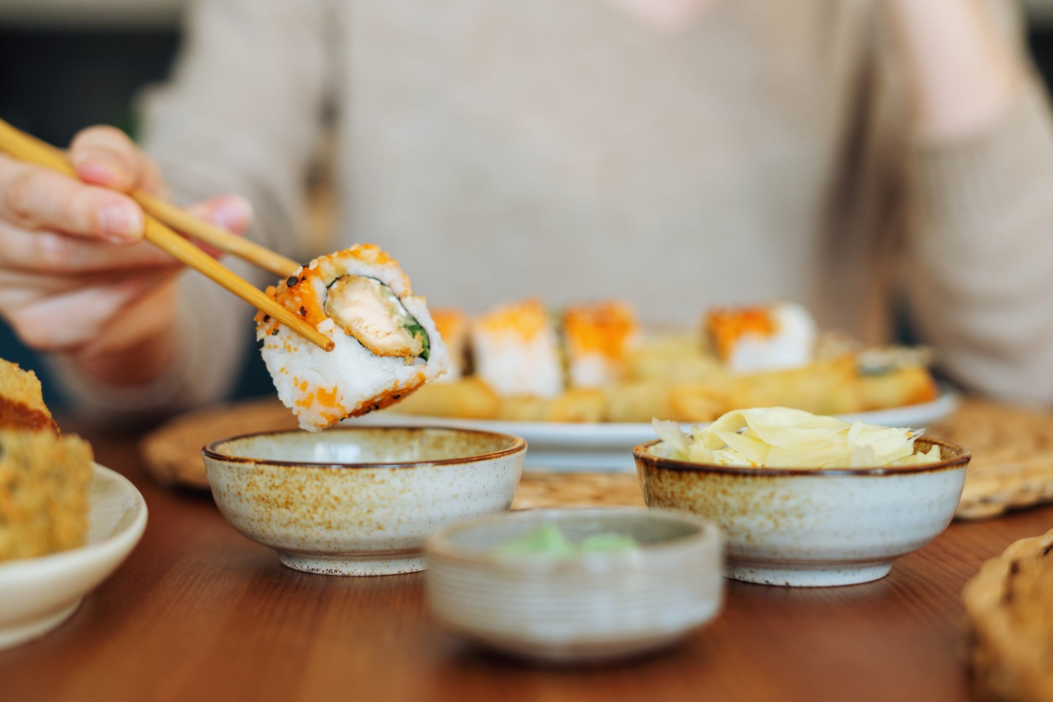 Close up view of someone eating a piece of sushi