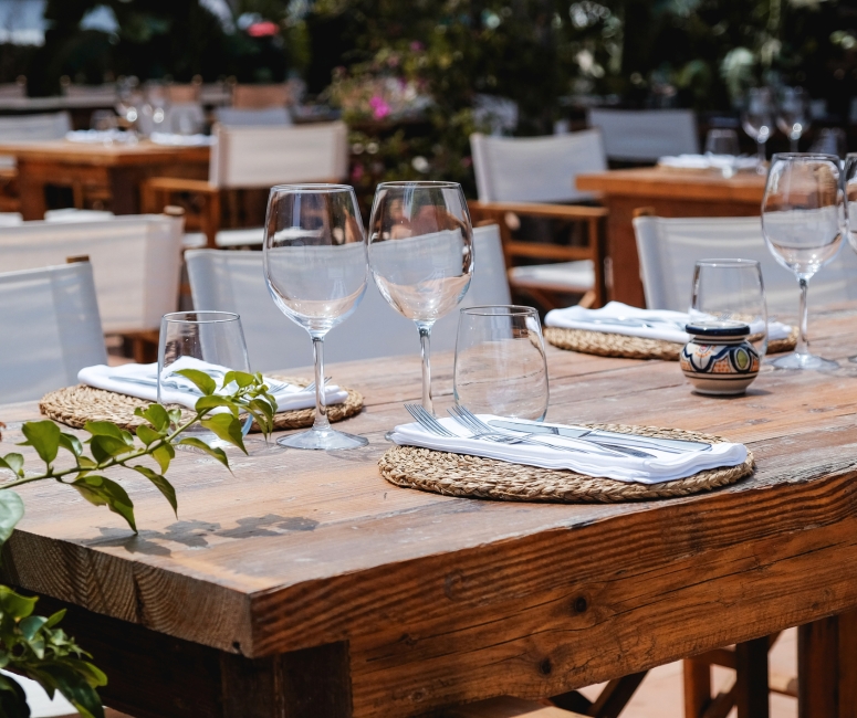 Close up view of glasses and silver ware set up on a table ready for guests to come and eat at Cobi's