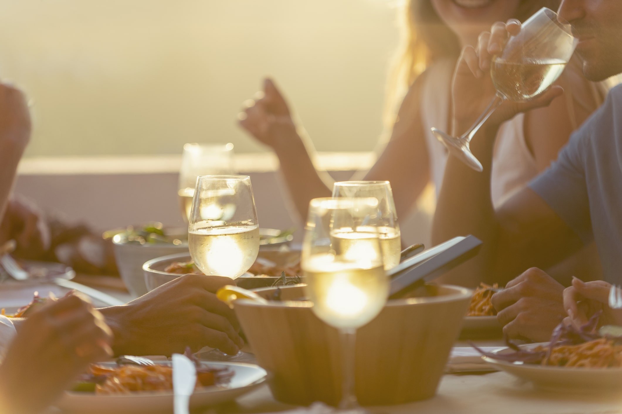 a group of people enjoying their dinner while eating outside