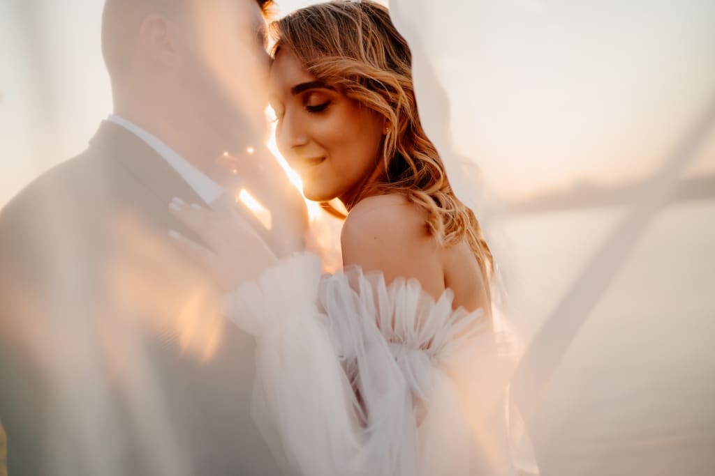 A bride and groom standing infront of a river
