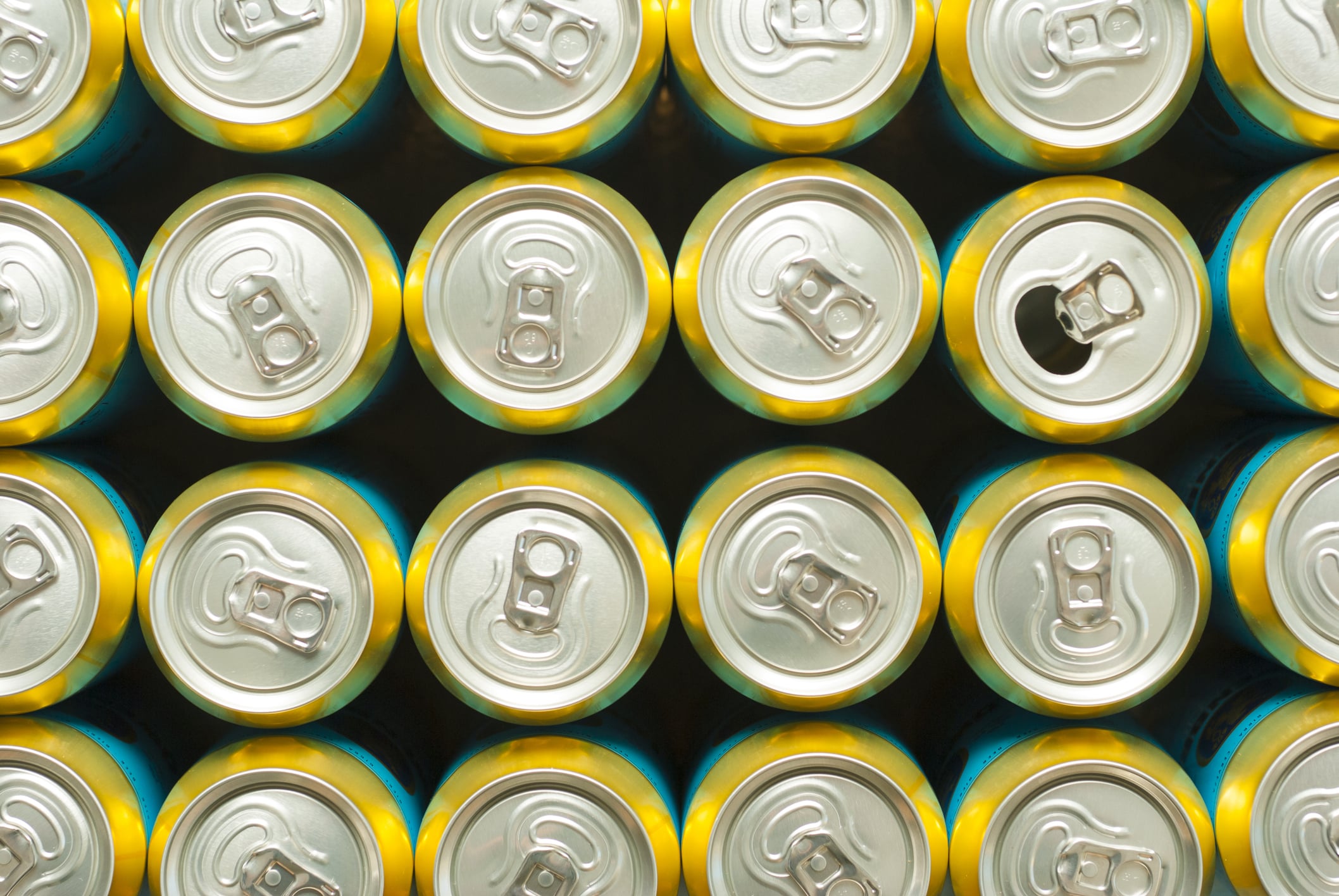 rows of unopened cans with a open can in the middle