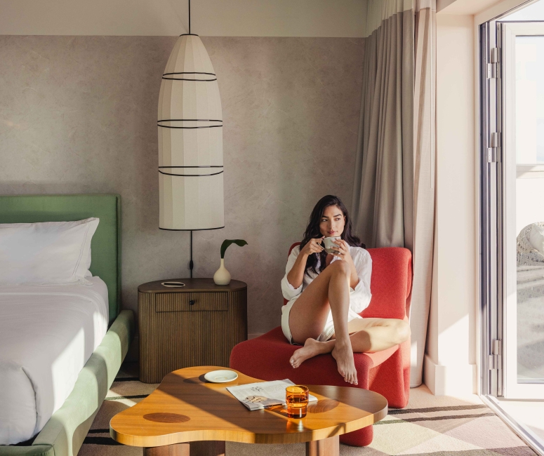 Woman sipping coffee in hotel room