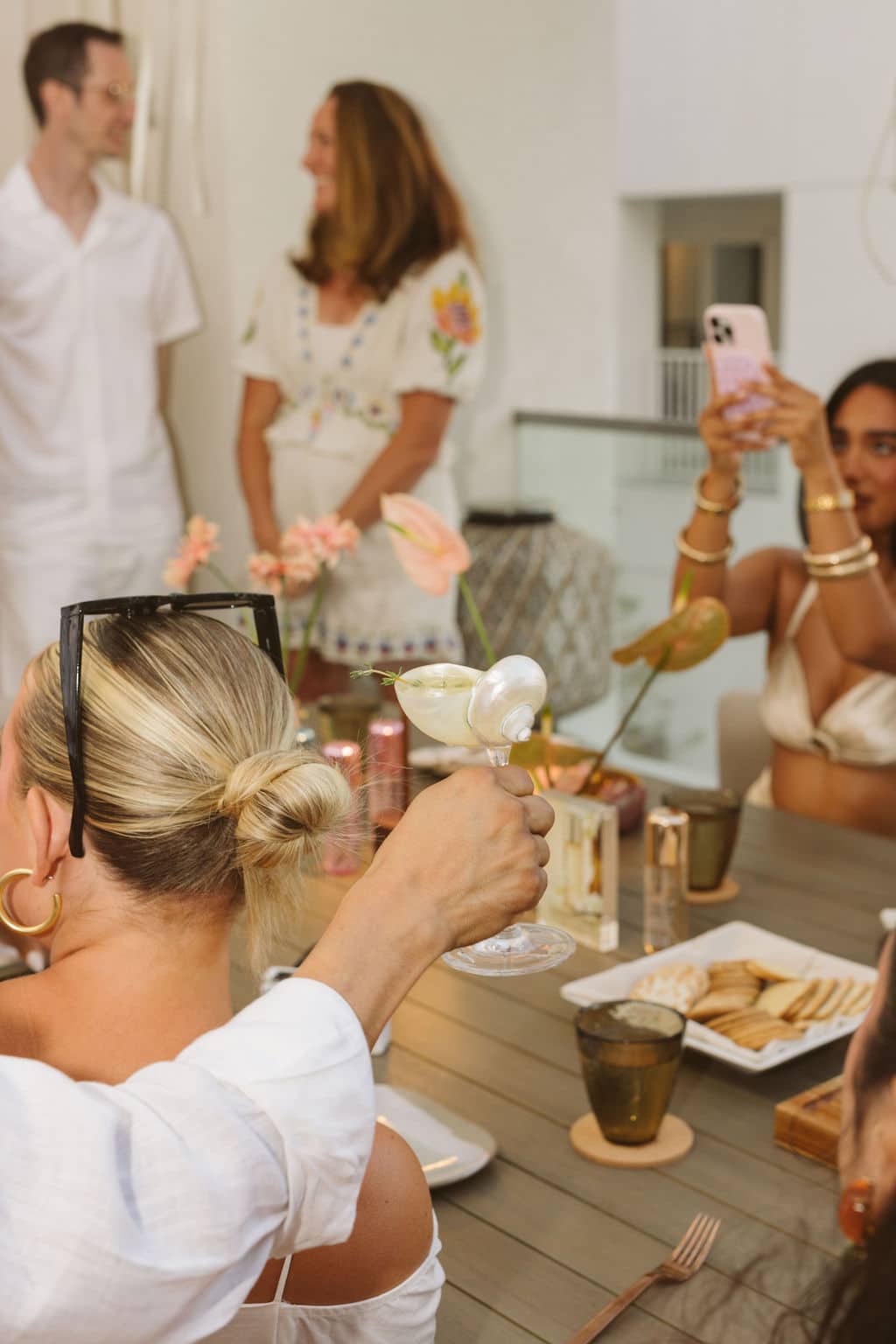 A group of people enjoying drinks and food at Sandbourne Santa Monica