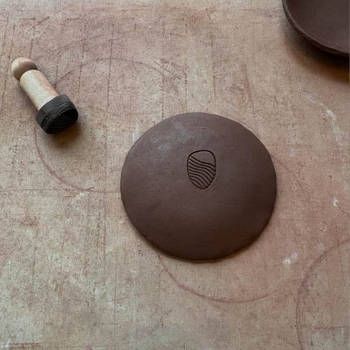 A brown bowl with the Sandbourne Santa Monica logo stamped in it